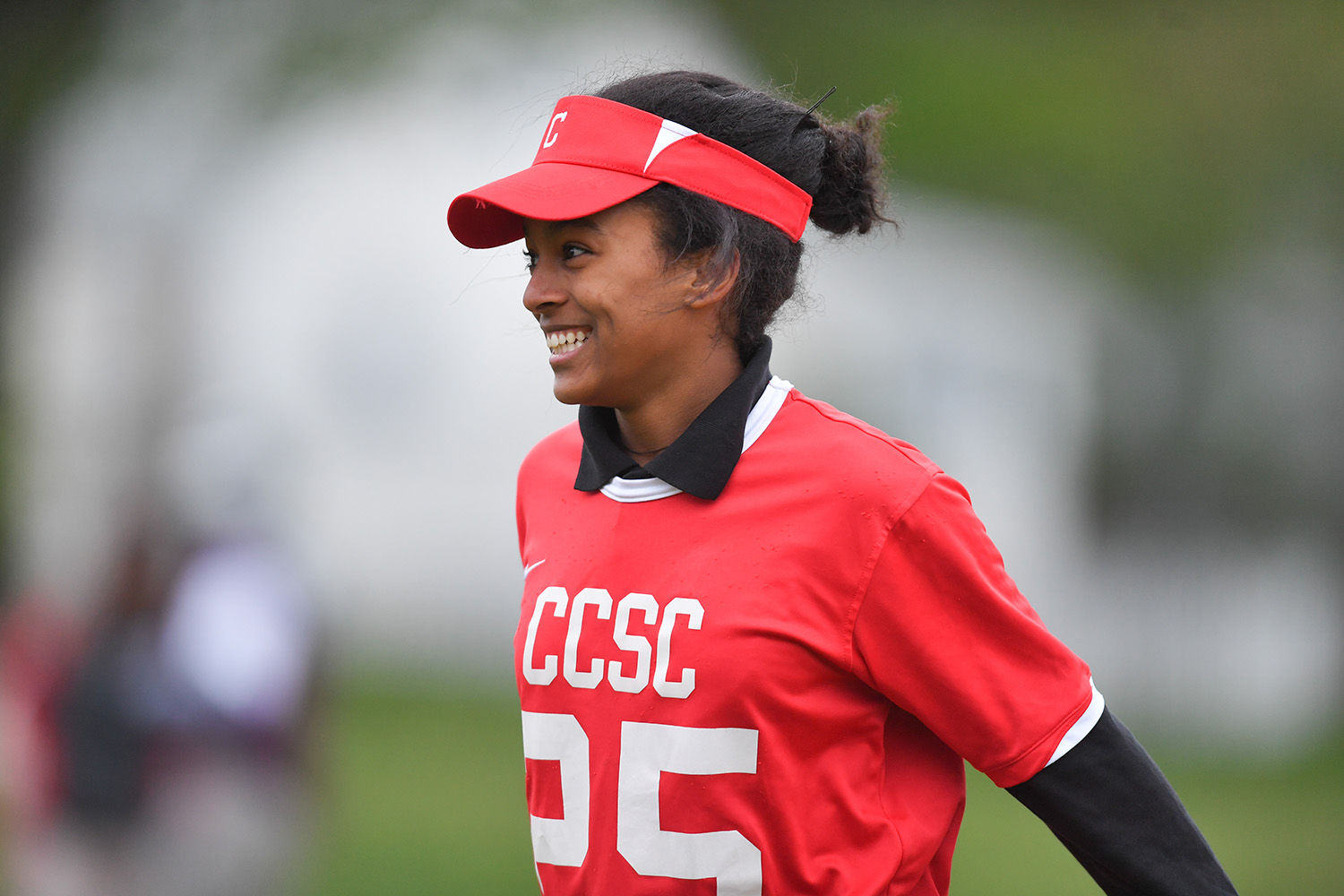 Photo of a softball player in uniform smiling