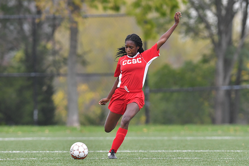Photo of a female soccer player kicking a ball