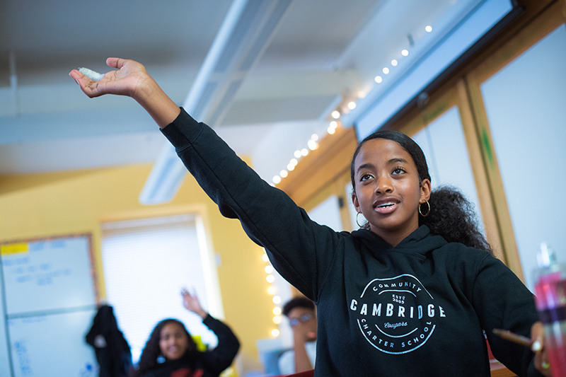 Photo of a girl raising her hand in class